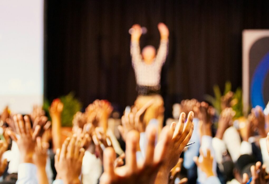 people raising hands with bokeh lights